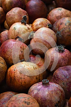 Purple pomegranates background, vertical. Ripe pomegranates on market. Juicy fruits. Vitamin and antioxidant