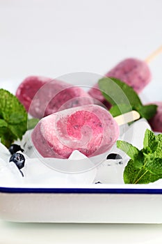 Purple Popsicles with Blueberries and Mint on Ice Cubes