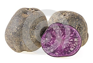 Purple potatoes on white background. Vitelotte potatoes