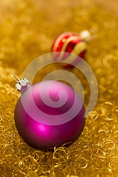 Purple and red christmas balls on gold glitter