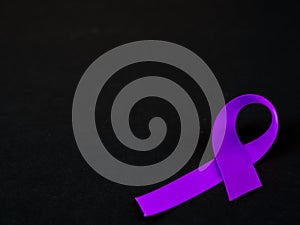 Purple ribbon awareness on black background .