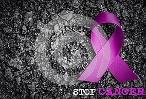 Purple ribbon awareness on dark background with STOP CANCER word