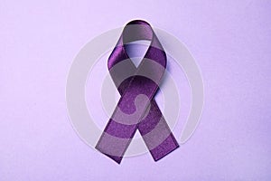 Purple ribbon on lilac background. Domestic violence awareness