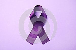 Purple ribbon on lilac background. Domestic violence awareness
