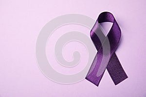 Purple ribbon on pink background, top view. Domestic violence awareness