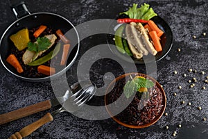 Purple rice berries cooked with grilled chicken breast Pumpkin Carrot Leaves The mint leaves in the dish and the spoon, fork,