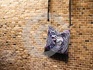 Purple Satin 7th Chakra Ohm Purse on a Brick Wall