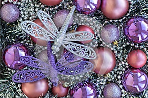 Purple and silver dragonflies on purple and violet Christmas balls. Christmas background. New Year concept