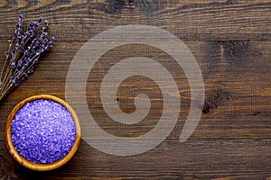 Purple spa salt for aroma therapy with lavender flower fragrance on wooden background top view copyspace