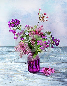 Purple spring bouquet flowers in a glass vase