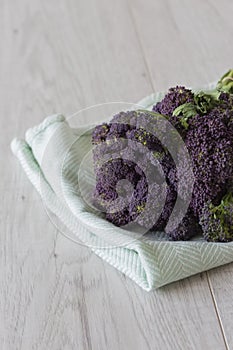 Purple sprouting broccoli bunch on a green tea towel