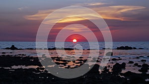 Purple sunset over sea and rocks