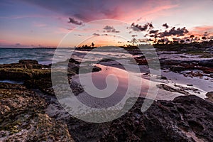 Purple sunset over a tropical rocky beach