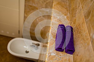 Purple towels in the bathroom in rolls