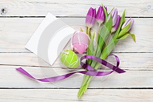 Purple tulip bouquet, easter eggs and blank greeting card