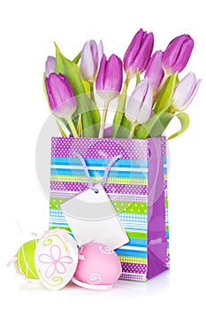 Purple tulip bouquet in gift bag and easter eggs