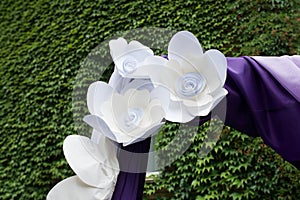 Purple wedding arch decorated with paper flowers, lilac and purple material close up. flowers.