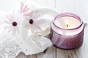 Purple White Daisies and purple candle on dreamy background.  Still life for Mothers Day and Valentines Day