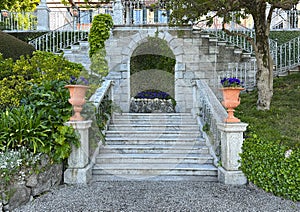 Purple wild pansies in a terracotta planters flanking steps in the Garden of the Villa Cipressi in Varenna. photo