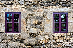 Purple window on medieval castle made of stone and rocks. photo