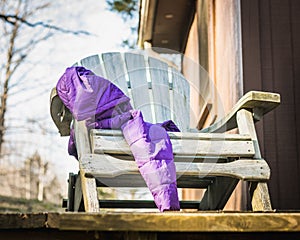 Purple Winter Coat Draped over an Aqua Adirondack Chair