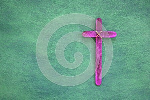 Purple wooden cross flat lay in green background. Holy week and lent season celebration concept.