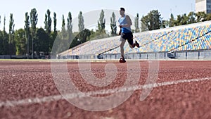 Purposeful Hispanic athlete running at stadium, preparing for marathon, sport