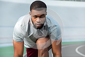 Purposeful serious professional young sportsman preparing for running