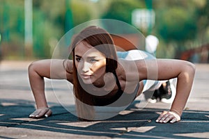 Purposeful woman does push-ups. Sports training, active lifestyle for the thirties