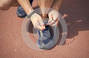 In pursuit of good health. Male hands lace sport shoe. Athletic shoe on arena ground. Gym shoe. Tying shoelaces