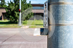 Push button at cross walk busy street intersection in a city photo