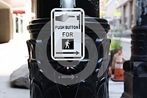 Push button for pedestrian crossing sign at a crosswalk.