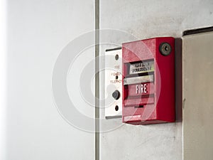 Push button switch, fire alarm on grey wall for alarm and security system with fire extinguisher port