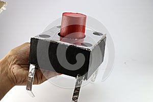 Push button is usually small in size replicated to a large sized switch using cardboard and aluminum foil held in the hand photo