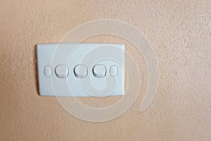 Push button of white switch on orange wall