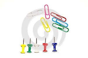 Push pins and paper clips in different colors isolated on white background.