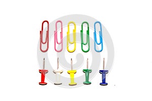 Push pins and paper clips in different colors isolated on white background.