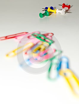 Push pins and paper clips in different colors isolated on white background.