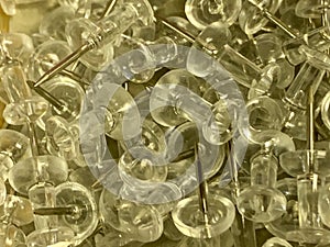 Push Pins in a pile on wooden desk close up