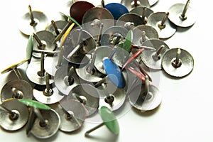 Push pins on a white background. Colored and silver buttons. Many and one. Blue, Yellow, Red