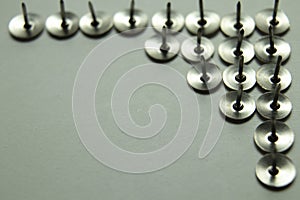 Push pins on a white background. Colored and silver buttons. Many and one. Blue, Yellow, Red