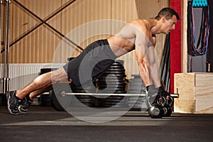 Push up on kettlebells in a gym