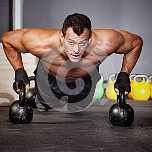 Push up on kettlebells man doing fitness training