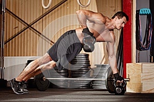 Push up on kettlebells man doing fitness training photo