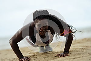 Push-ups fitness african woman doing pushups outside on beach