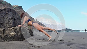 Push-ups fitness woman doing pushups outside on beach working out. Fit female sport model girl training crossfit