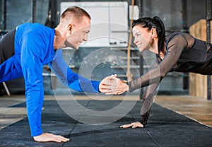 Push-ups together. Healthy couple in gym, workout with own body weight. Close ip photo.