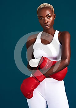 Push yourself to your limits. Cropped portrait of an attractive young female boxer standing with her boxing gloves