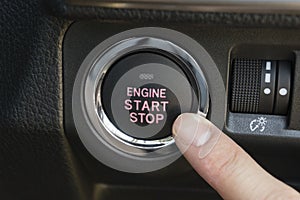 Pushing the engine start stop button of a car