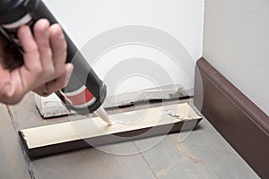 Pushing glue on the wooden baseboard